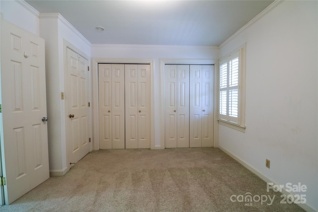 unfurnished bedroom with light carpet, two closets, and ornamental molding