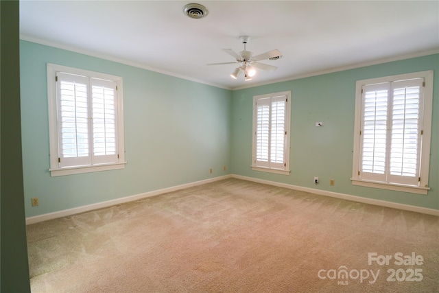 empty room featuring light colored carpet, ceiling fan, and crown molding