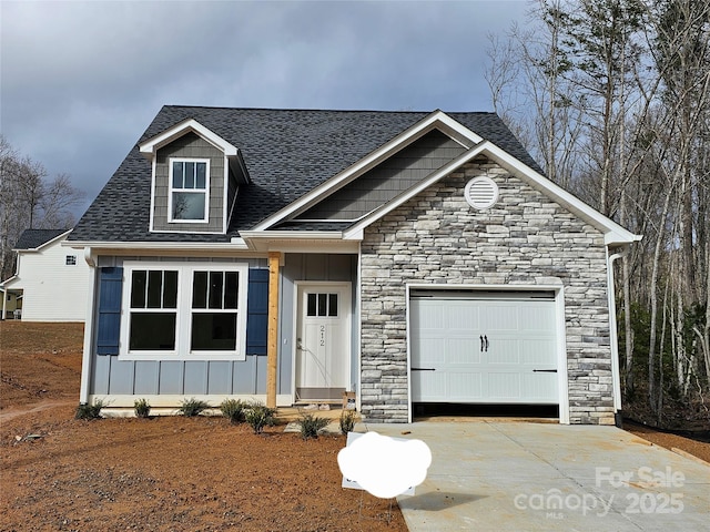 view of front of home with a garage, concrete driveway, board and batten siding, and roof with shingles