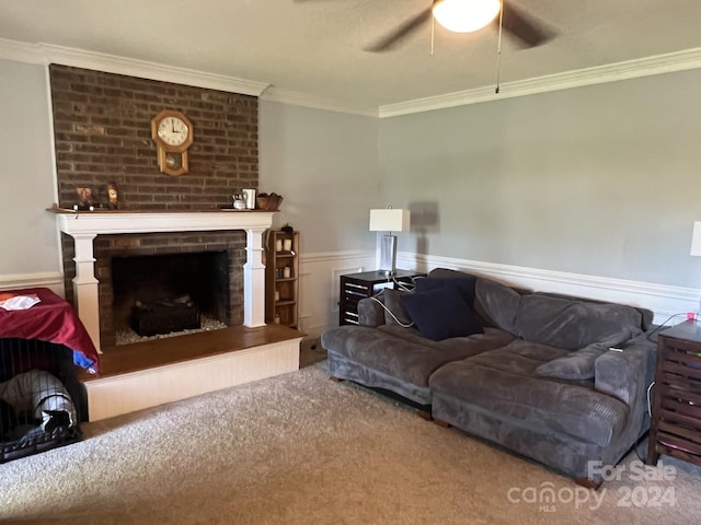 carpeted living room featuring ceiling fan, a brick fireplace, and crown molding