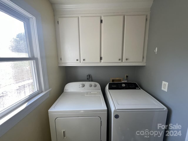 laundry room featuring cabinets and washer and clothes dryer