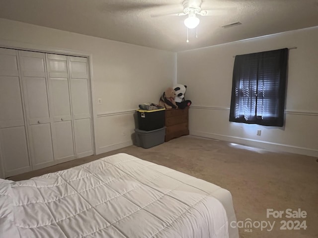 unfurnished bedroom with ceiling fan, light colored carpet, and a closet