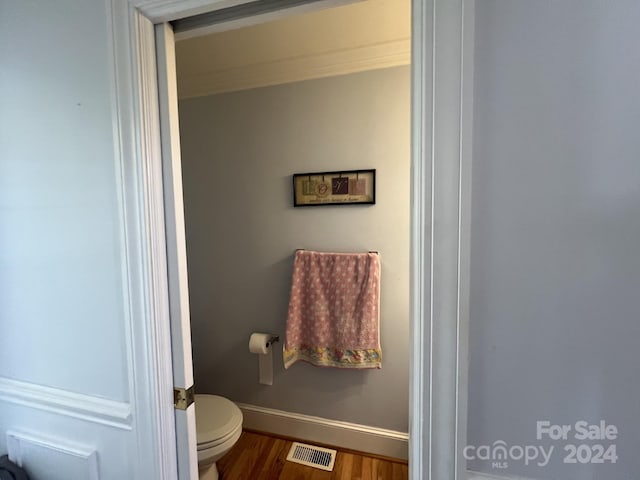 bathroom featuring wood-type flooring and toilet