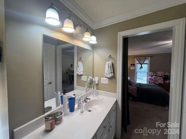 bathroom with a textured ceiling, ornamental molding, and vanity