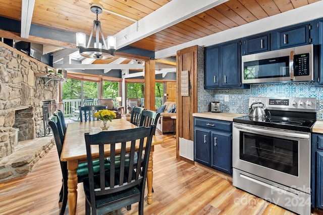 kitchen with light wood finished floors, tasteful backsplash, appliances with stainless steel finishes, blue cabinets, and beamed ceiling