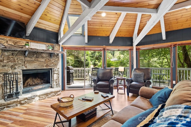 living room featuring vaulted ceiling with beams, a healthy amount of sunlight, and a fireplace