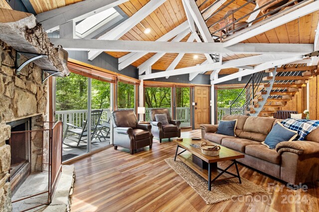 living room with beam ceiling, plenty of natural light, and wood ceiling