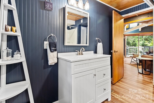 bathroom with wood walls, wooden ceiling, hardwood / wood-style flooring, and vanity