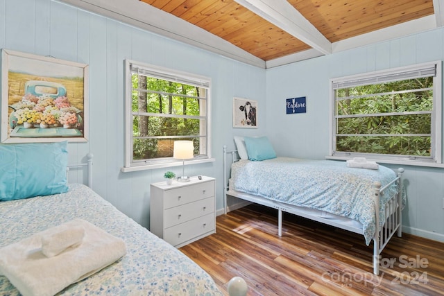 bedroom featuring lofted ceiling with beams, wood ceiling, baseboards, and wood finished floors