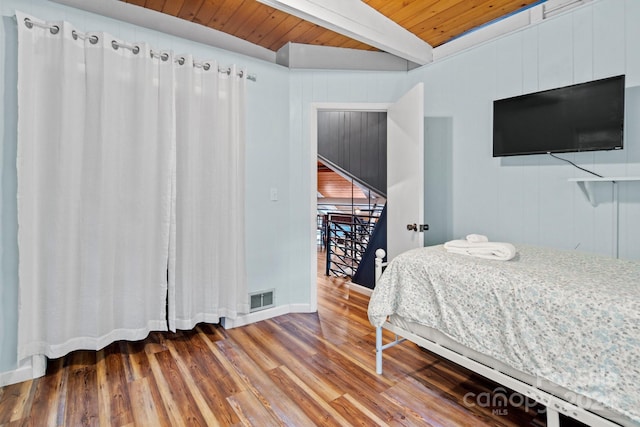 bedroom with lofted ceiling with beams, hardwood / wood-style flooring, and wood ceiling