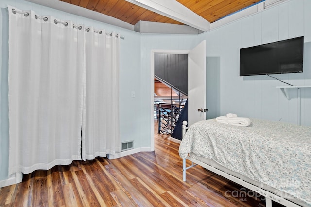 bedroom with wood ceiling, beamed ceiling, wood finished floors, and visible vents