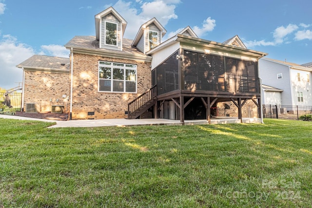 rear view of house featuring central air condition unit, a patio area, a sunroom, and a yard