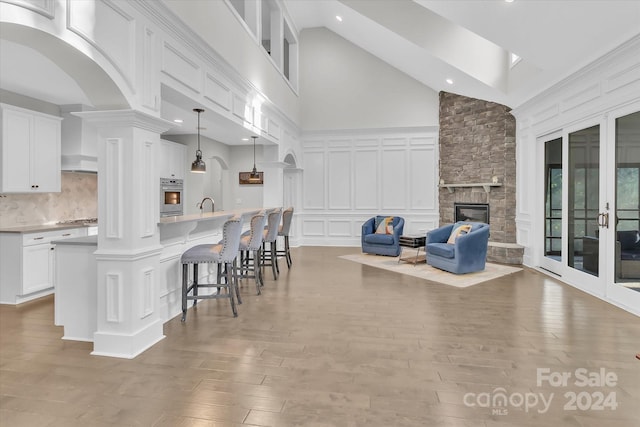 kitchen featuring white cabinetry, light hardwood / wood-style floors, decorative light fixtures, and appliances with stainless steel finishes