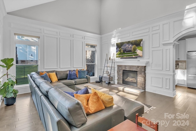 living room with a fireplace, hardwood / wood-style floors, and high vaulted ceiling