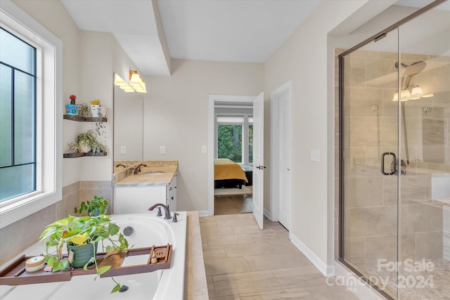 bathroom with plus walk in shower, vanity, tile patterned floors, and a healthy amount of sunlight