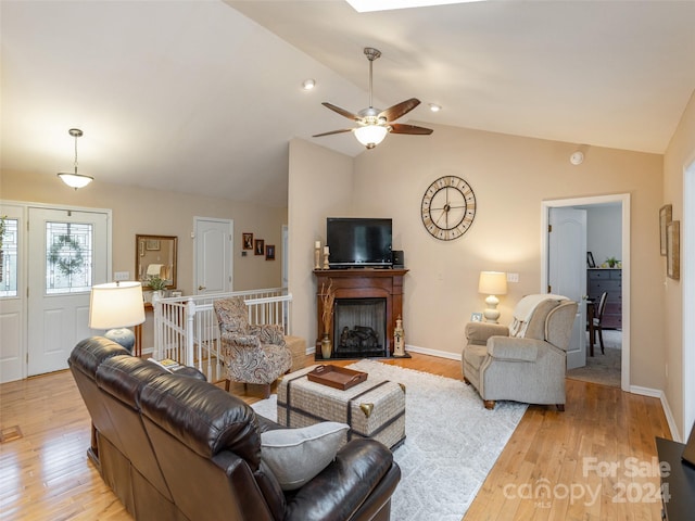 living room featuring ceiling fan, light hardwood / wood-style flooring, and lofted ceiling