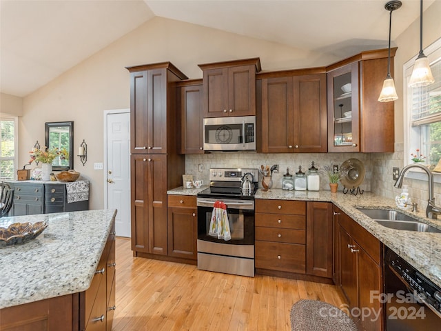 kitchen featuring sink, light wood-type flooring, appliances with stainless steel finishes, and lofted ceiling