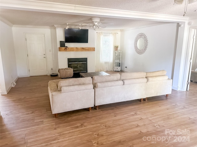 living room featuring light wood-type flooring, ceiling fan, and ornamental molding