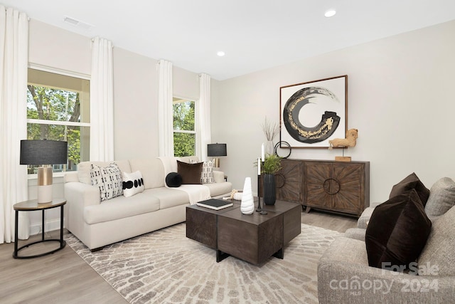 living area with wood finished floors, visible vents, and recessed lighting