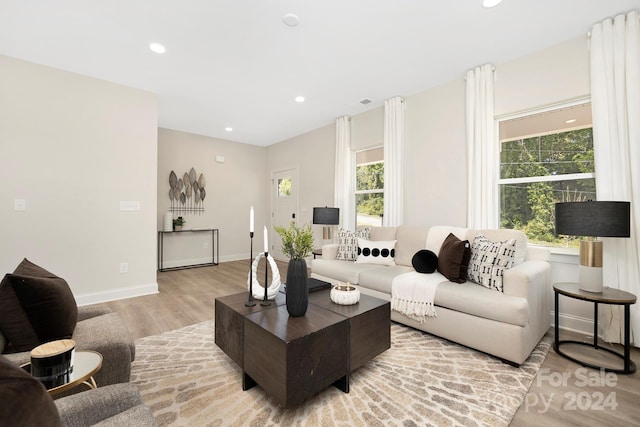 living room with light wood finished floors, baseboards, and recessed lighting