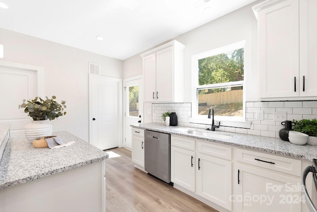 kitchen featuring light wood-style flooring, a sink, visible vents, a wealth of natural light, and dishwasher