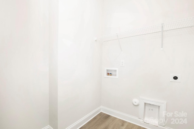 clothes washing area featuring gas dryer hookup, hookup for a washing machine, hookup for an electric dryer, laundry area, and light wood finished floors