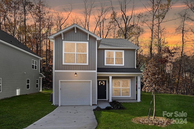 view of front of house featuring a garage and a yard