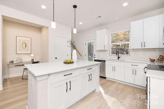 kitchen featuring sink, pendant lighting, dishwasher, white cabinets, and light hardwood / wood-style floors