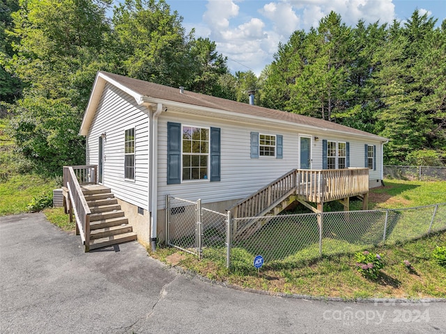 view of front of home with a front lawn and a wooden deck