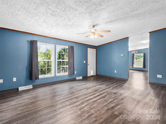 empty room with crown molding, visible vents, plenty of natural light, and dark wood-type flooring