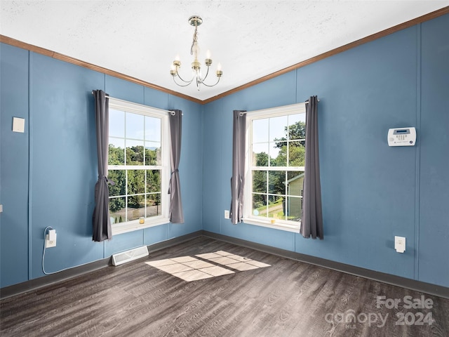 empty room with dark wood finished floors, visible vents, a chandelier, vaulted ceiling, and crown molding