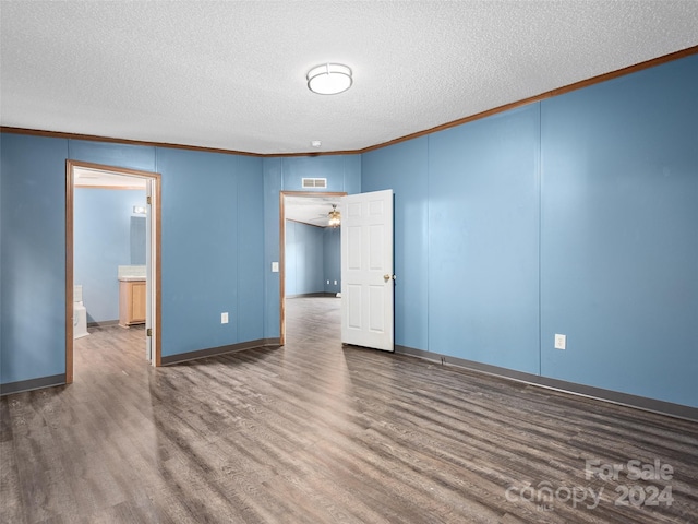 unfurnished room with crown molding, dark wood-style floors, and visible vents