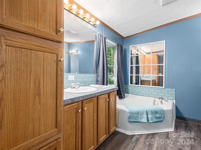 full bathroom featuring ornamental molding, decorative backsplash, a textured ceiling, a bath, and wood finished floors