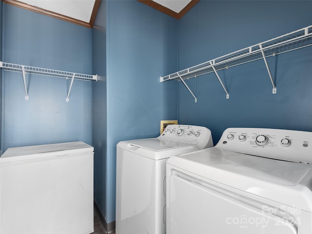 laundry room featuring washer and dryer, crown molding, and laundry area