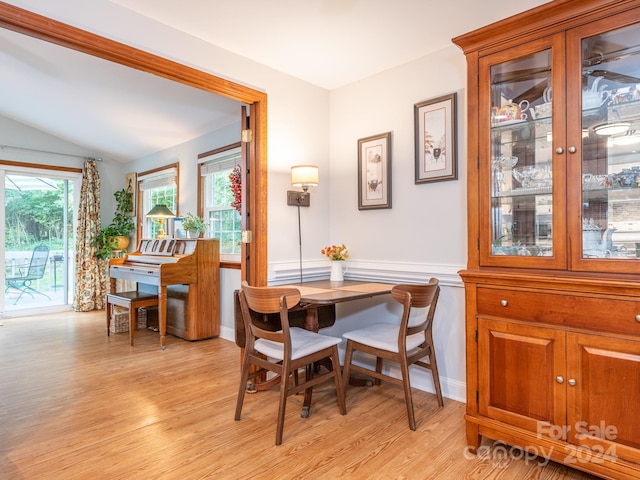 dining area with a wealth of natural light, vaulted ceiling, and light wood-type flooring