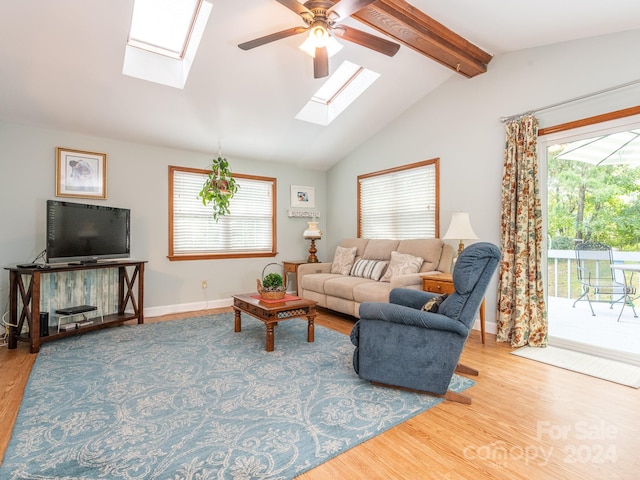 living room with hardwood / wood-style flooring, ceiling fan, and vaulted ceiling with beams