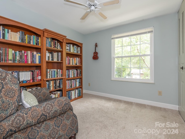 living area with ceiling fan and light carpet