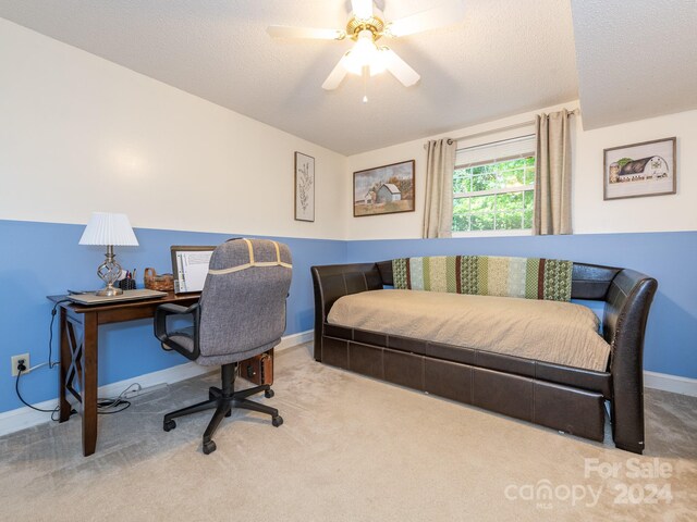 office area with ceiling fan, carpet, and a textured ceiling