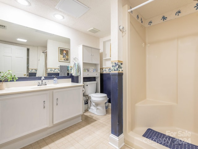 bathroom featuring a shower with curtain, vanity, a textured ceiling, and toilet