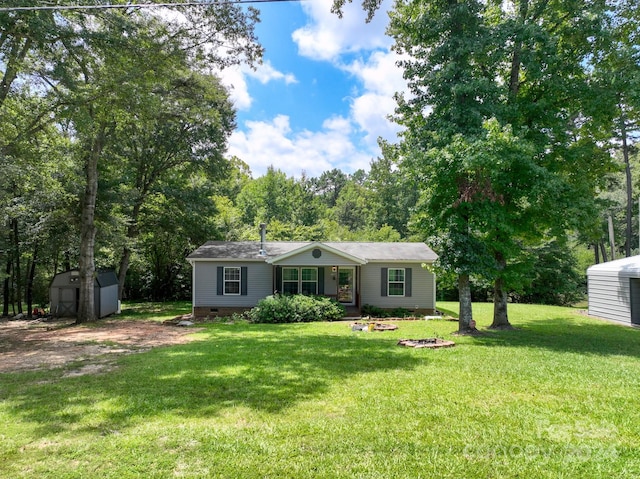 single story home featuring a front yard and a storage shed