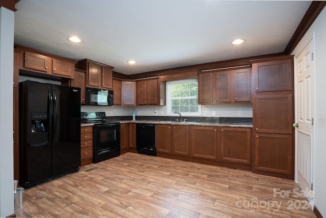 kitchen with sink, light hardwood / wood-style floors, and black appliances