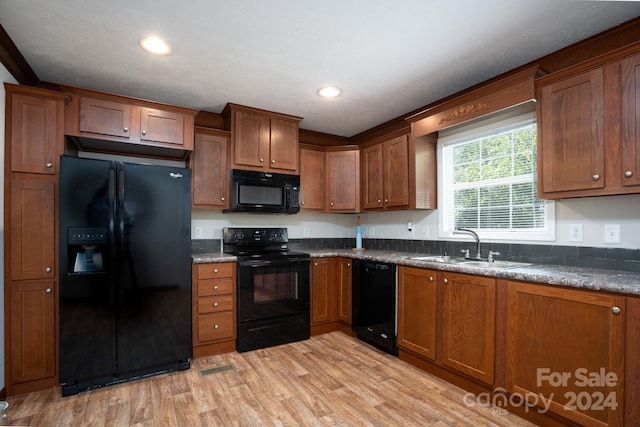 kitchen with sink, light wood-type flooring, and black appliances