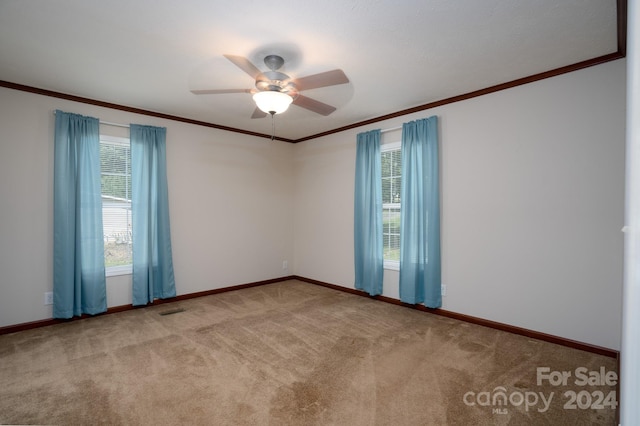 empty room with a wealth of natural light, ceiling fan, and light colored carpet