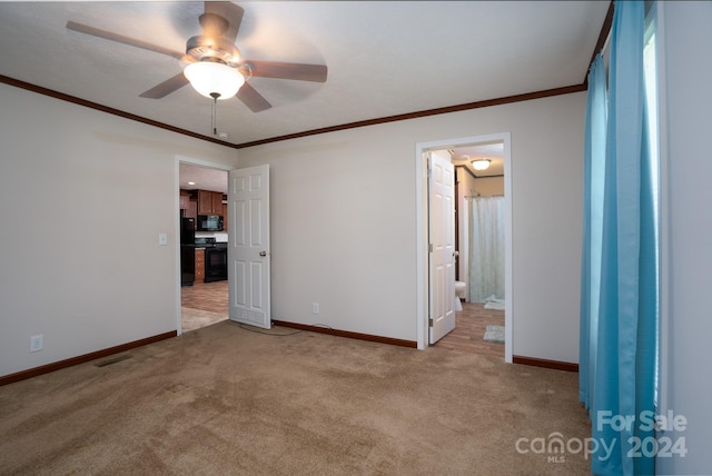 carpeted empty room featuring ceiling fan and crown molding