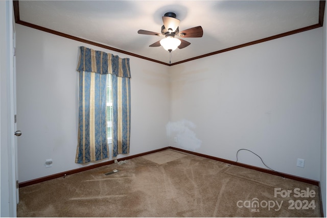 empty room with carpet, crown molding, and ceiling fan