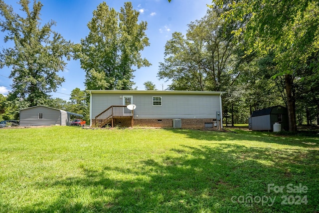 rear view of house featuring a lawn and a shed