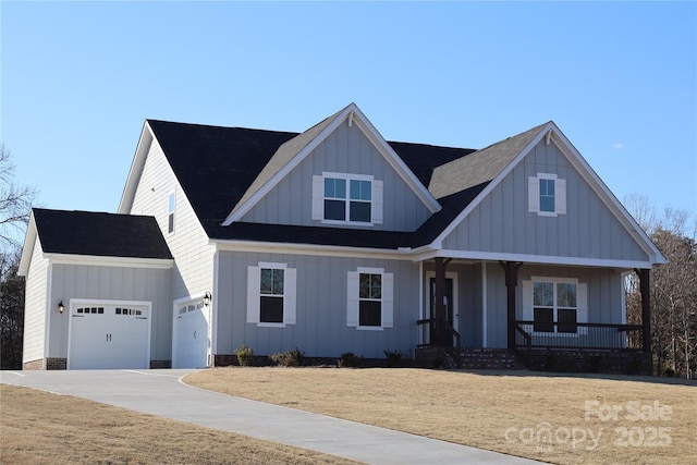 view of front facade with a front lawn, covered porch, an attached garage, board and batten siding, and driveway