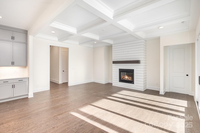 unfurnished living room featuring coffered ceiling, dark wood-type flooring, a fireplace, and beam ceiling