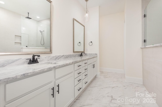 bathroom featuring a tile shower and vanity