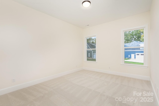 unfurnished room featuring a healthy amount of sunlight and light colored carpet